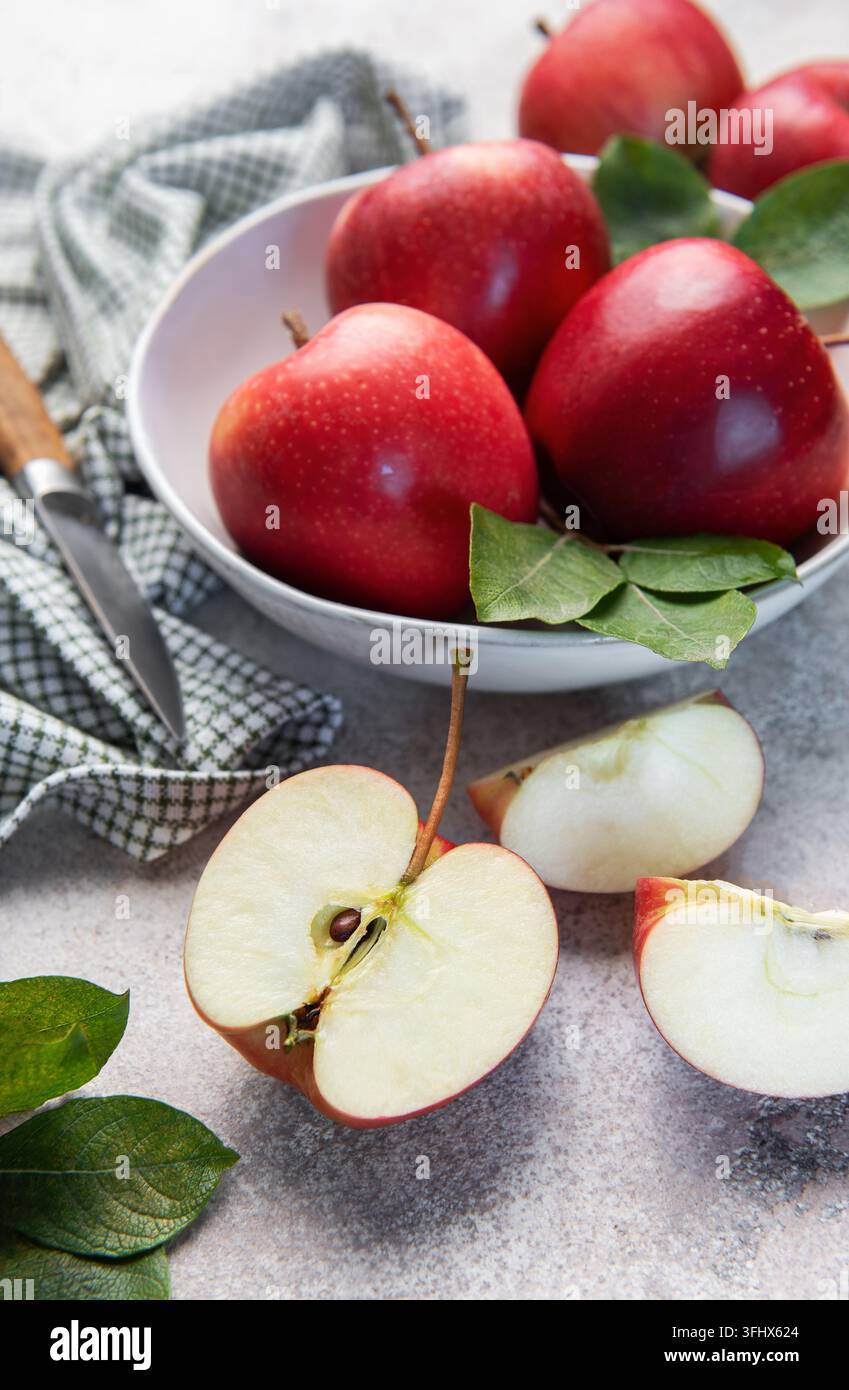 Mele rosse fresche in una ciotola con coltello Foto Stock