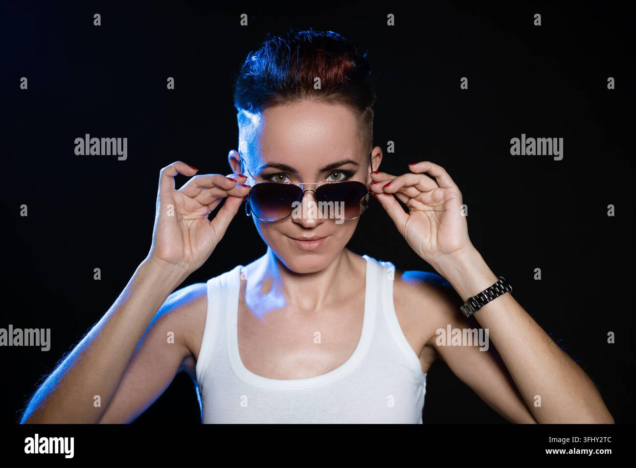 Ritratto ravvicinato di una donna dai capelli corti e alla moda che tiene le mani su un rotondo elegante Foto Stock