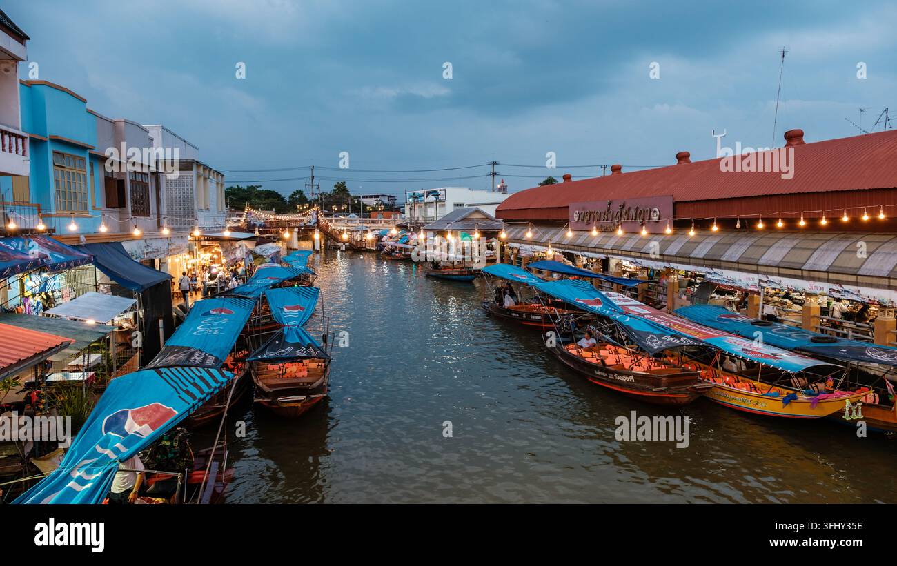 Esplora l'atmosfera vivace del Mercato Fluttuante di Amphawa in Thailandia in una deliziosa serata Foto Stock