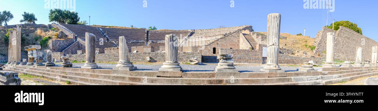 Vista panoramica che mostra la gradinata in pietra semicircolare del teatro romano antico all'Asclepio di Pergamo, fronteggiata da una fila di pietre rotte e in piedi Foto Stock