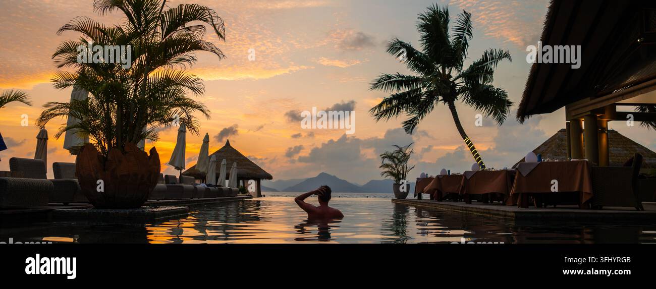 Serenità al tramonto in piscina alle Seychelles, una perfetta fuga tropicale Foto Stock