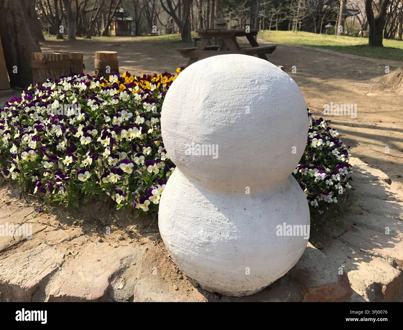 Primo piano di una scultura di pupazzo di neve bianco con viole a Nami Island, luogo delle riprese di Winter Sonata. Namiso Island, Corea del Sud. 11 aprile 2017 Foto Stock