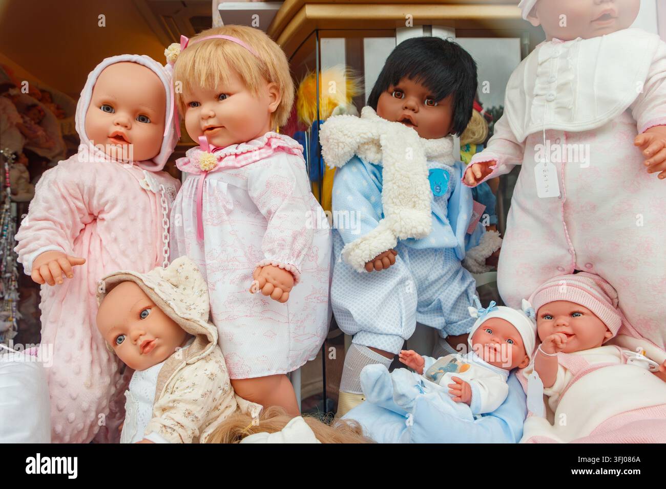 Bambole Reborn vestite con abiti blu e bianchi esposti in un cesto Foto Stock