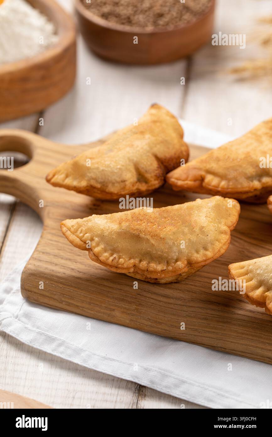Mini pasticcini chebureki fritti su tavola di legno Foto Stock