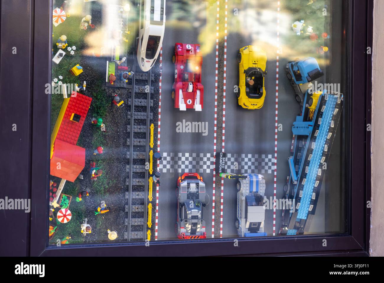 Szklarska Poręba, Polonia – 18 dicembre 2025: Blocchi di costruzione in miniatura colorati disposti come un circuito da corsa con modelli di veicoli per ispirare l'im Foto Stock