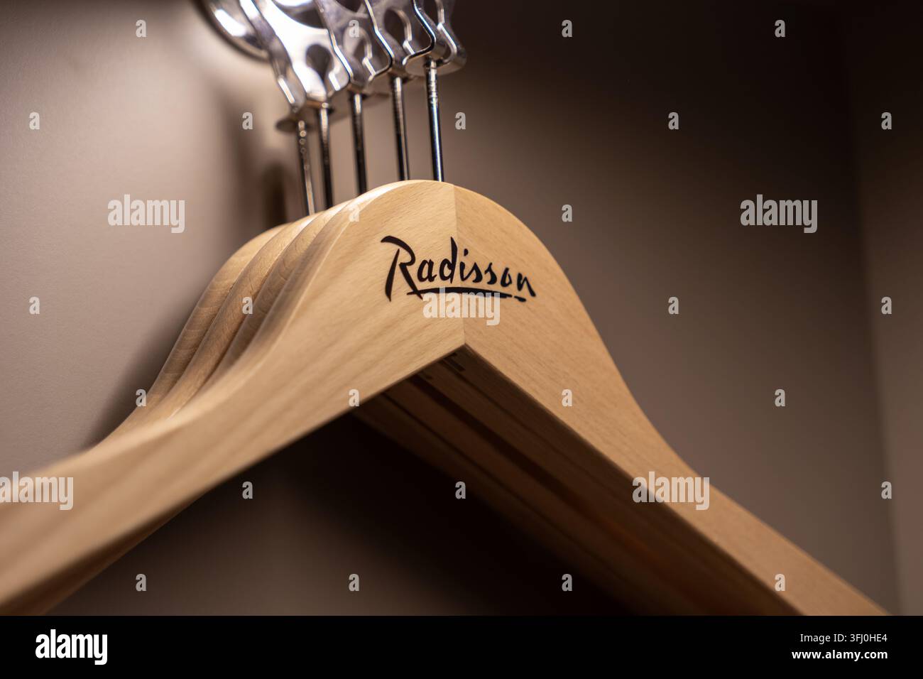 Szklarska Poręba, Polonia – 20 dicembre 2025: appendiabiti in legno di marca Radisson all’interno di un armadio scuro di un hotel, evidenziando servizi di qualità e profession Foto Stock