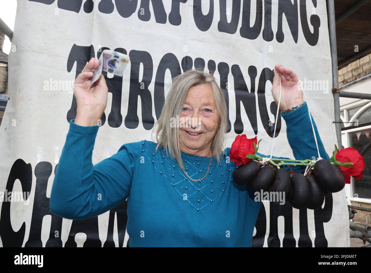 13 settembre 2026. Ramsbottom, Bury, Lancashire, Regno Unito. La Competizione Mondiale di Lancio del Black Pudding si svolge la seconda domenica di settembre all'Oaks Public House. I concorrenti si trovano su una 'Griglia Dorata', che viene ceremonialmente sfilata prima di essere posizionata davanti alla porta del pub. Tre black puddings fatti con sangue di maiale, rusk e grasso racchiusi in intestini vengono lanciati sotto mano su 12 Yorkshire Puddings su un plinto a 6 metri di altezza su un plinto di legno. Il vincitore è la persona che ne abbatte di più con 3 puddings. Quest'anno c'erano 4 vincitori ex aequo, tra cui la prima donna, e als Foto Stock
