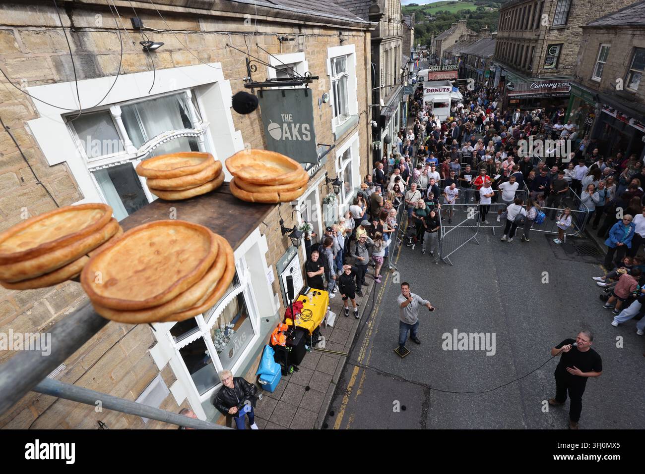13 settembre 2026. Ramsbottom, Bury, Lancashire, Regno Unito. La Competizione Mondiale di Lancio del Black Pudding si svolge la seconda domenica di settembre all'Oaks Public House. I concorrenti si trovano su una 'Griglia Dorata', che viene ceremonialmente sfilata prima di essere posizionata davanti alla porta del pub. Tre black puddings fatti con sangue di maiale, rusk e grasso racchiusi in intestini vengono lanciati sotto mano su 12 Yorkshire Puddings su un plinto a 6 metri di altezza su un plinto di legno. Il vincitore è la persona che ne abbatte di più con 3 puddings. Quest'anno c'erano 4 vincitori ex aequo, tra cui la prima donna, e als Foto Stock