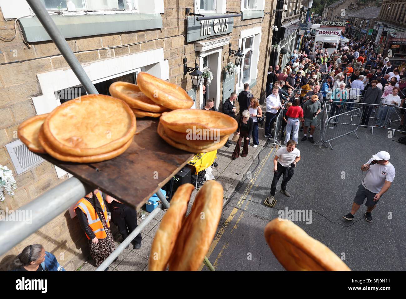 13 settembre 2026. Ramsbottom, Bury, Lancashire, Regno Unito. La Competizione Mondiale di Lancio del Black Pudding si svolge la seconda domenica di settembre all'Oaks Public House. I concorrenti si trovano su una 'Griglia Dorata', che viene ceremonialmente sfilata prima di essere posizionata davanti alla porta del pub. Tre black puddings fatti con sangue di maiale, rusk e grasso racchiusi in intestini vengono lanciati sotto mano su 12 Yorkshire Puddings su un plinto a 6 metri di altezza su un plinto di legno. Il vincitore è la persona che ne abbatte di più con 3 puddings. Quest'anno c'erano 4 vincitori ex aequo, tra cui la prima donna, e als Foto Stock