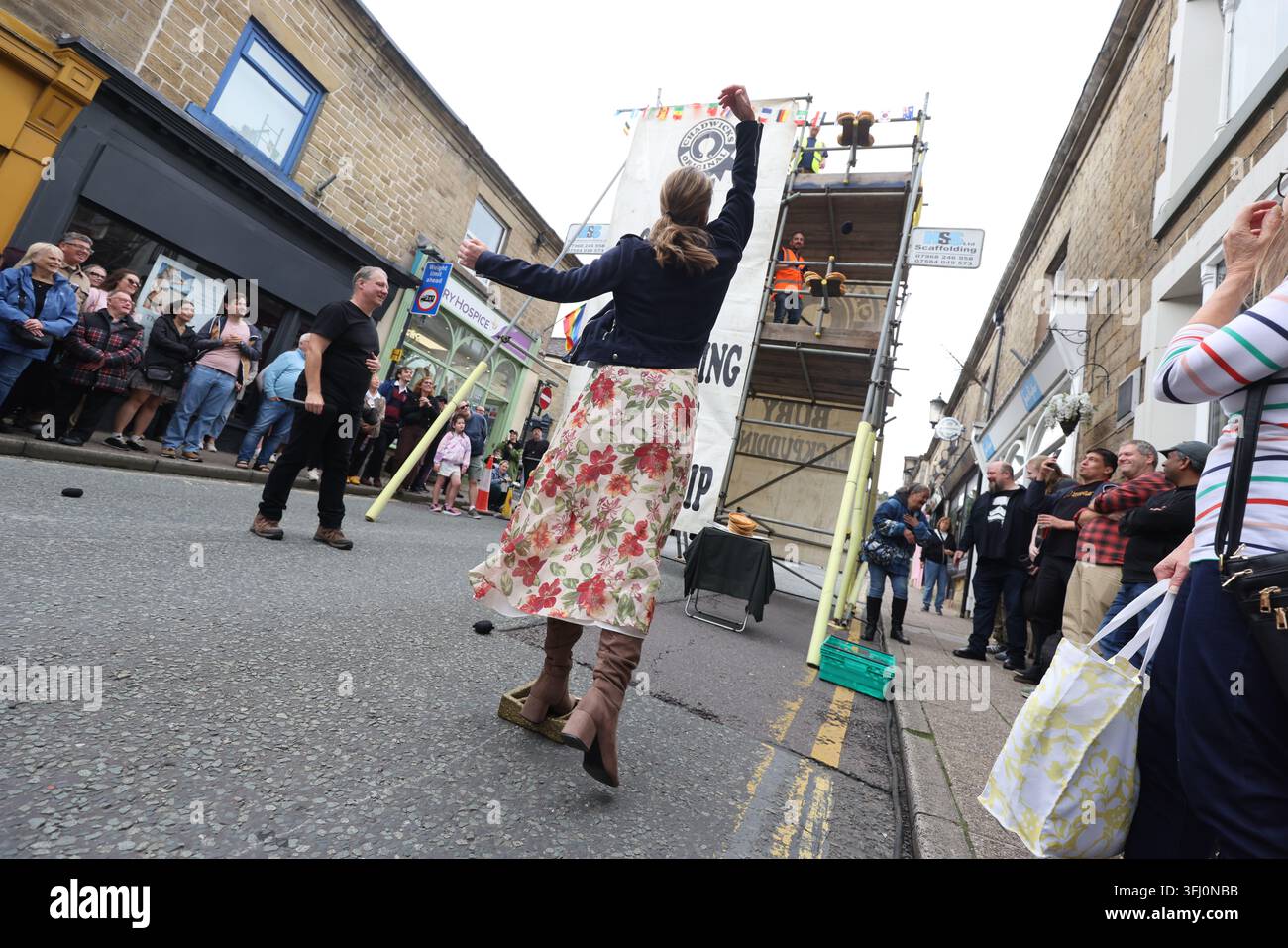 13 settembre 2026. Ramsbottom, Bury, Lancashire, Regno Unito. La Competizione Mondiale di Lancio del Black Pudding si svolge la seconda domenica di settembre all'Oaks Public House. I concorrenti si trovano su una 'Griglia Dorata', che viene ceremonialmente sfilata prima di essere posizionata davanti alla porta del pub. Tre black puddings fatti con sangue di maiale, rusk e grasso racchiusi in intestini vengono lanciati sotto mano su 12 Yorkshire Puddings su un plinto a 6 metri di altezza su un plinto di legno. Il vincitore è la persona che ne abbatte di più con 3 puddings. Quest'anno c'erano 4 vincitori ex aequo, tra cui la prima donna, e als Foto Stock