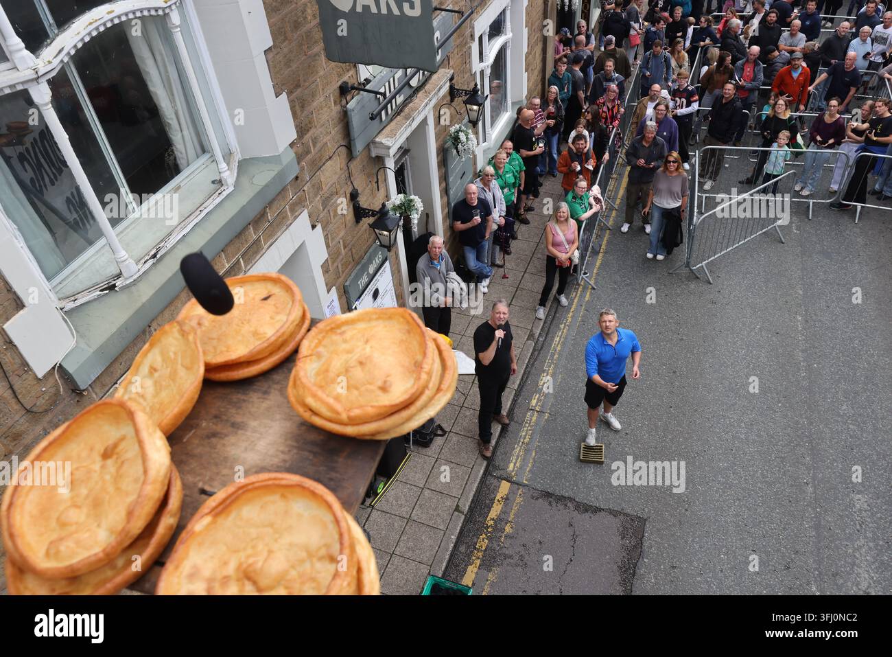 13 settembre 2026. Ramsbottom, Bury, Lancashire, Regno Unito. La Competizione Mondiale di Lancio del Black Pudding si svolge la seconda domenica di settembre all'Oaks Public House. I concorrenti si trovano su una 'Griglia Dorata', che viene ceremonialmente sfilata prima di essere posizionata davanti alla porta del pub. Tre black puddings fatti con sangue di maiale, rusk e grasso racchiusi in intestini vengono lanciati sotto mano su 12 Yorkshire Puddings su un plinto a 6 metri di altezza su un plinto di legno. Il vincitore è la persona che ne abbatte di più con 3 puddings. Quest'anno c'erano 4 vincitori ex aequo, tra cui la prima donna, e als Foto Stock