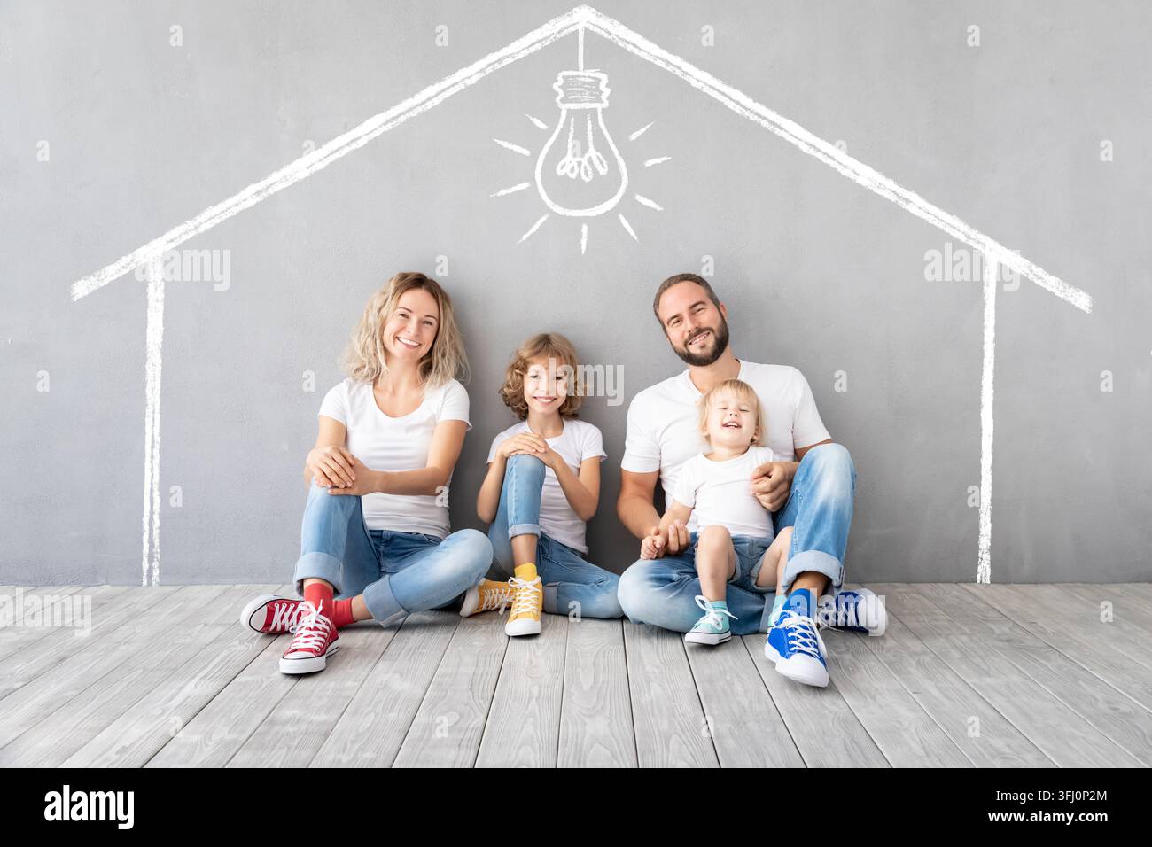 Famiglia felice con due bambini che giocano nella nuova casa Foto Stock