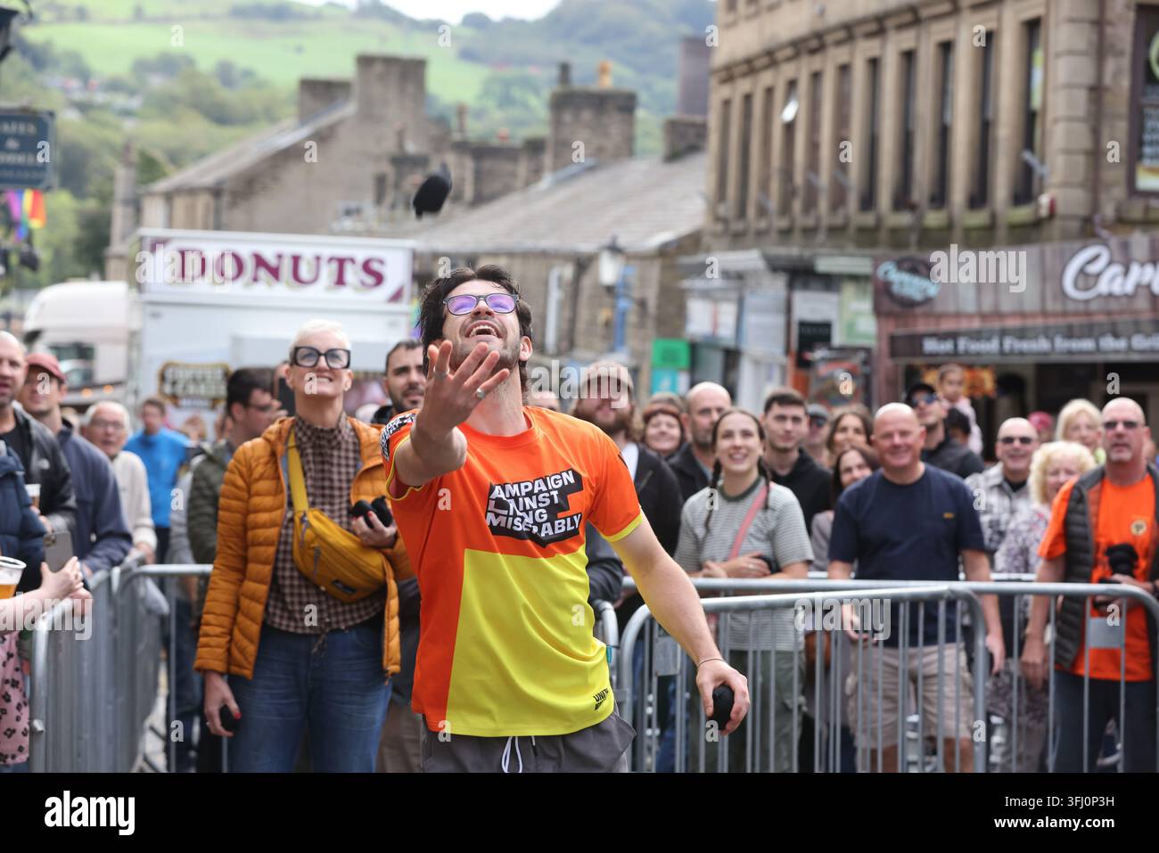 13 settembre 2026. Ramsbottom, Bury, Lancashire, Regno Unito. La Competizione Mondiale di Lancio del Black Pudding si svolge la seconda domenica di settembre all'Oaks Public House. I concorrenti si trovano su una 'Griglia Dorata', che viene ceremonialmente sfilata prima di essere posizionata davanti alla porta del pub. Tre black puddings fatti con sangue di maiale, rusk e grasso racchiusi in intestini vengono lanciati sotto mano su 12 Yorkshire Puddings su un plinto a 6 metri di altezza su un plinto di legno. Il vincitore è la persona che ne abbatte di più con 3 puddings. Quest'anno c'erano 4 vincitori ex aequo, tra cui la prima donna, e als Foto Stock