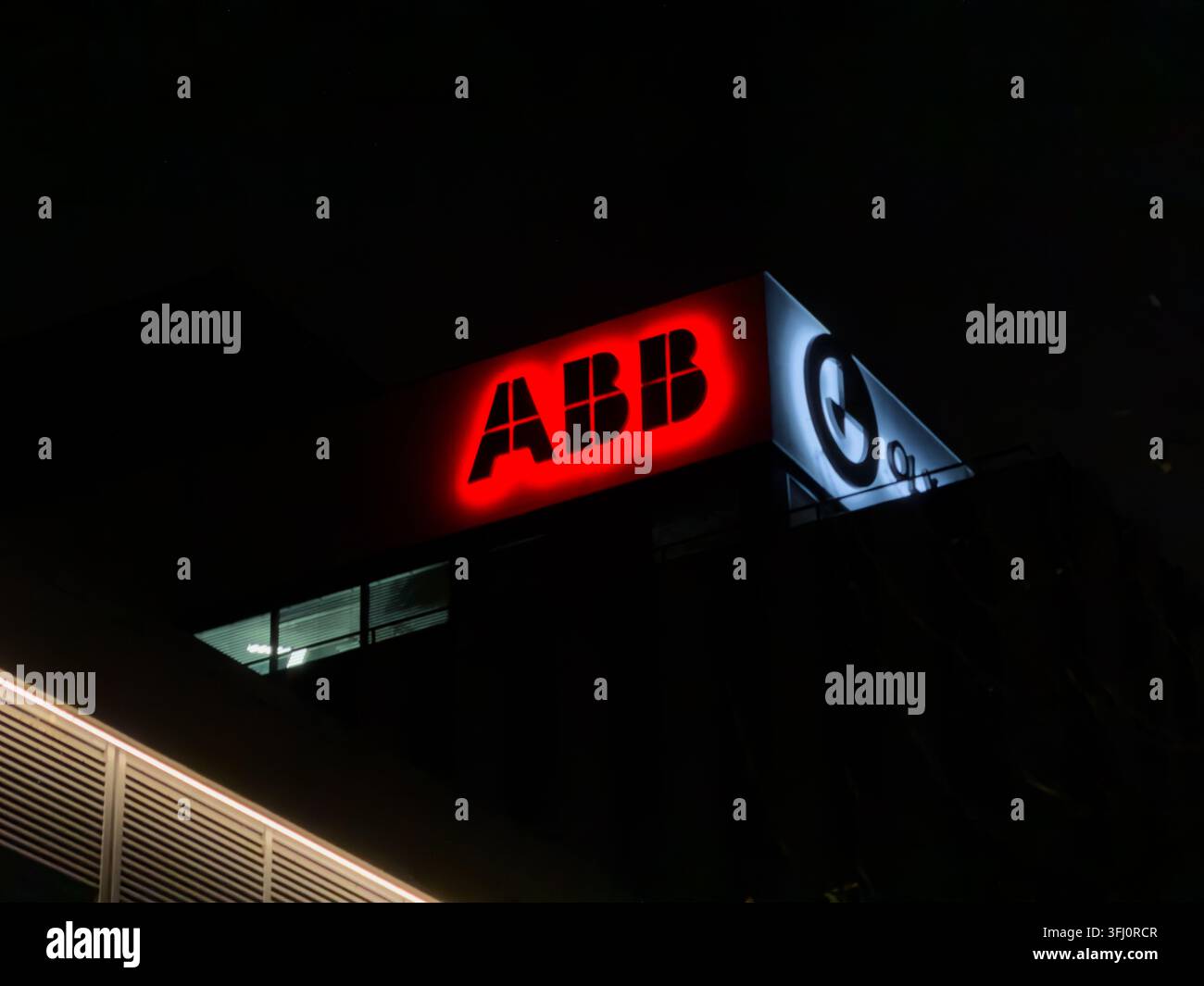 Poznań, Polonia – 29 dicembre 2025: Insegna luminosa ABB montata su una struttura di uffici commerciali di notte, che rappresenta il marchio tecnologico globale Foto Stock