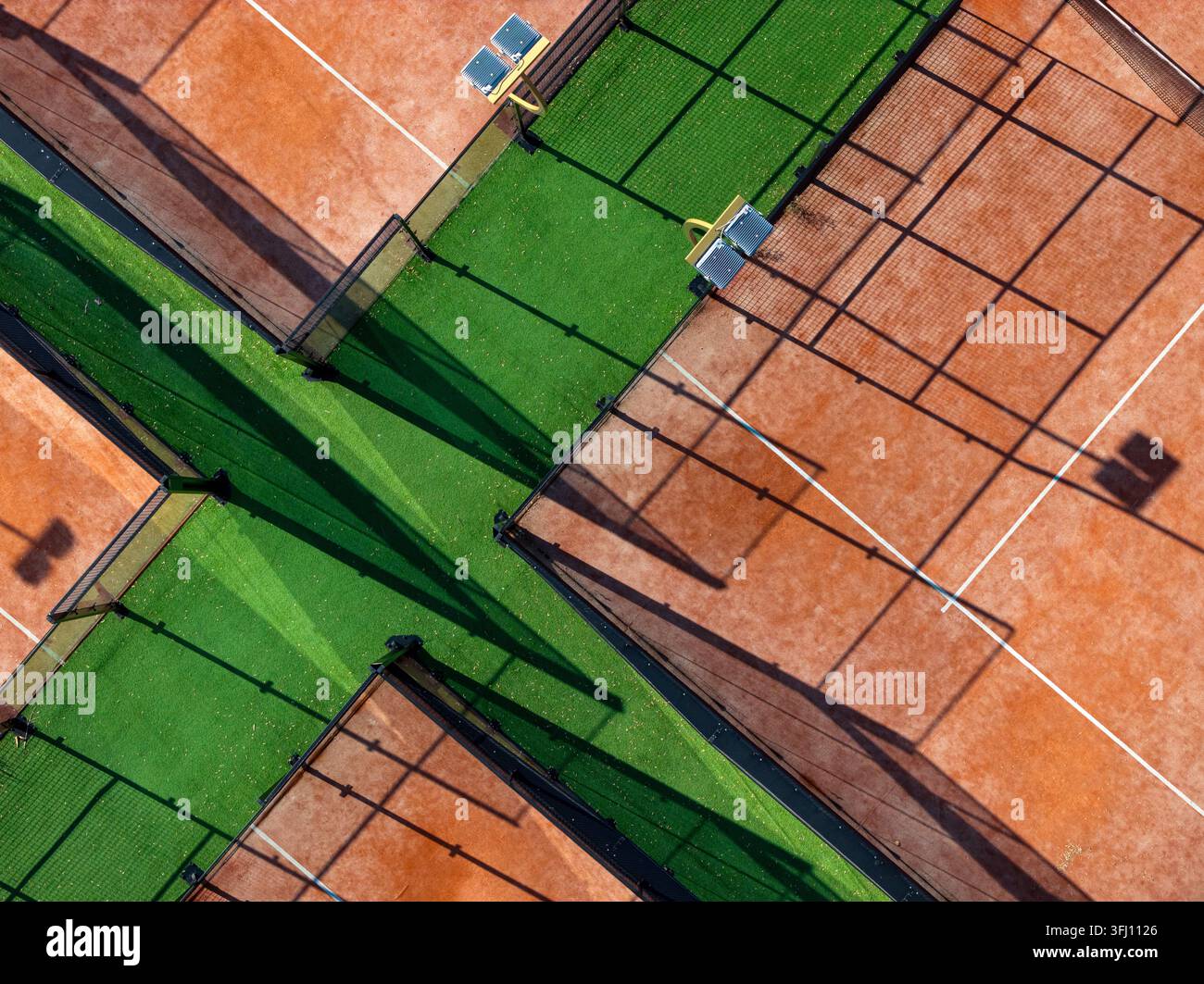 Vista aerea dei campi da tennis sul Danubio con superfici in terra battuta e moquette sintetica, reti e lunghe ombre proiettate dai riflettori a Belgrado, Serbia. Foto Stock
