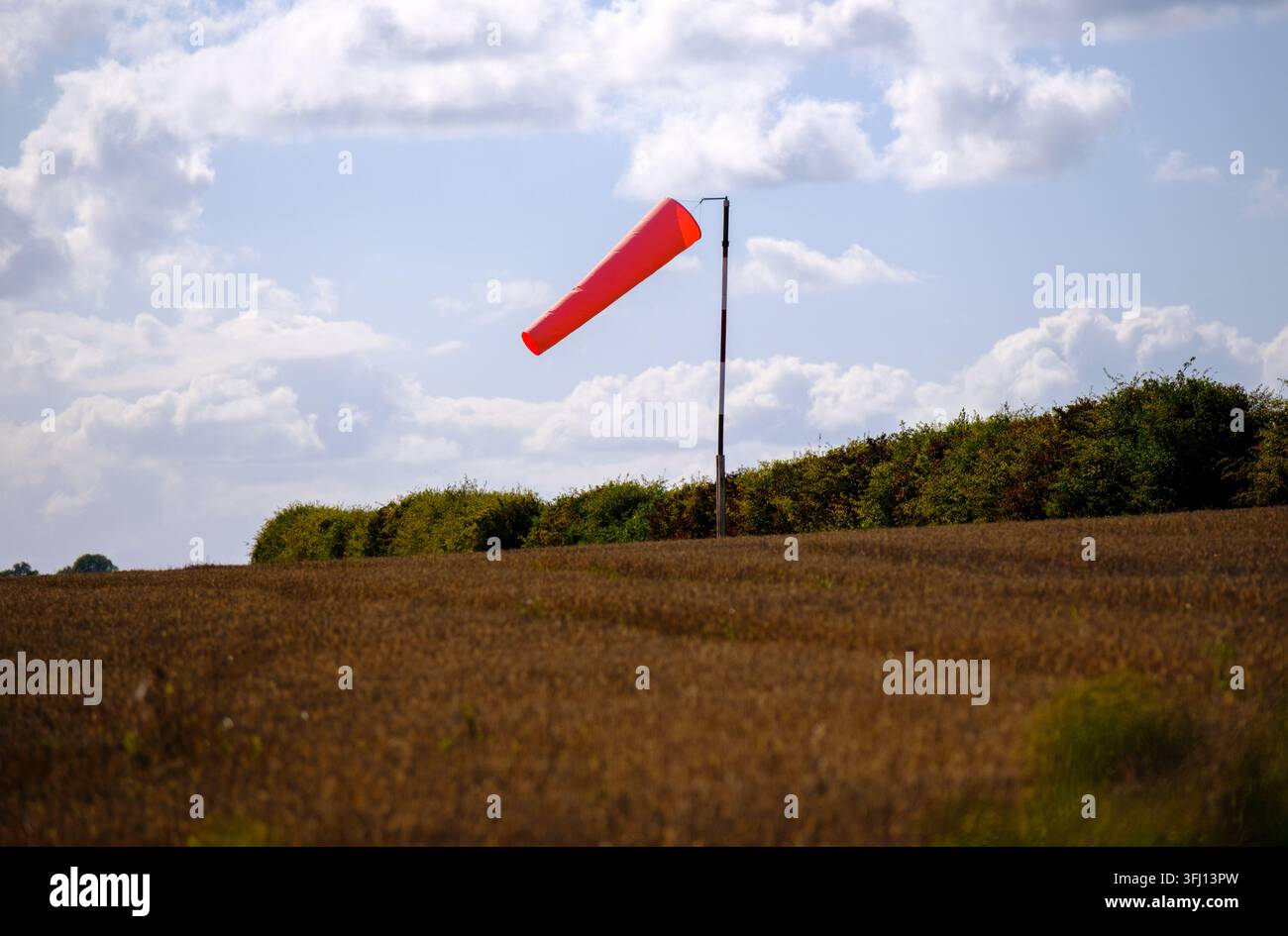Un parabrezza rosso in un aeroporto a Salisbury Wiltshire in Inghilterra mostra la direzione e la forza del vento, situato in un campo di campagna Foto Stock
