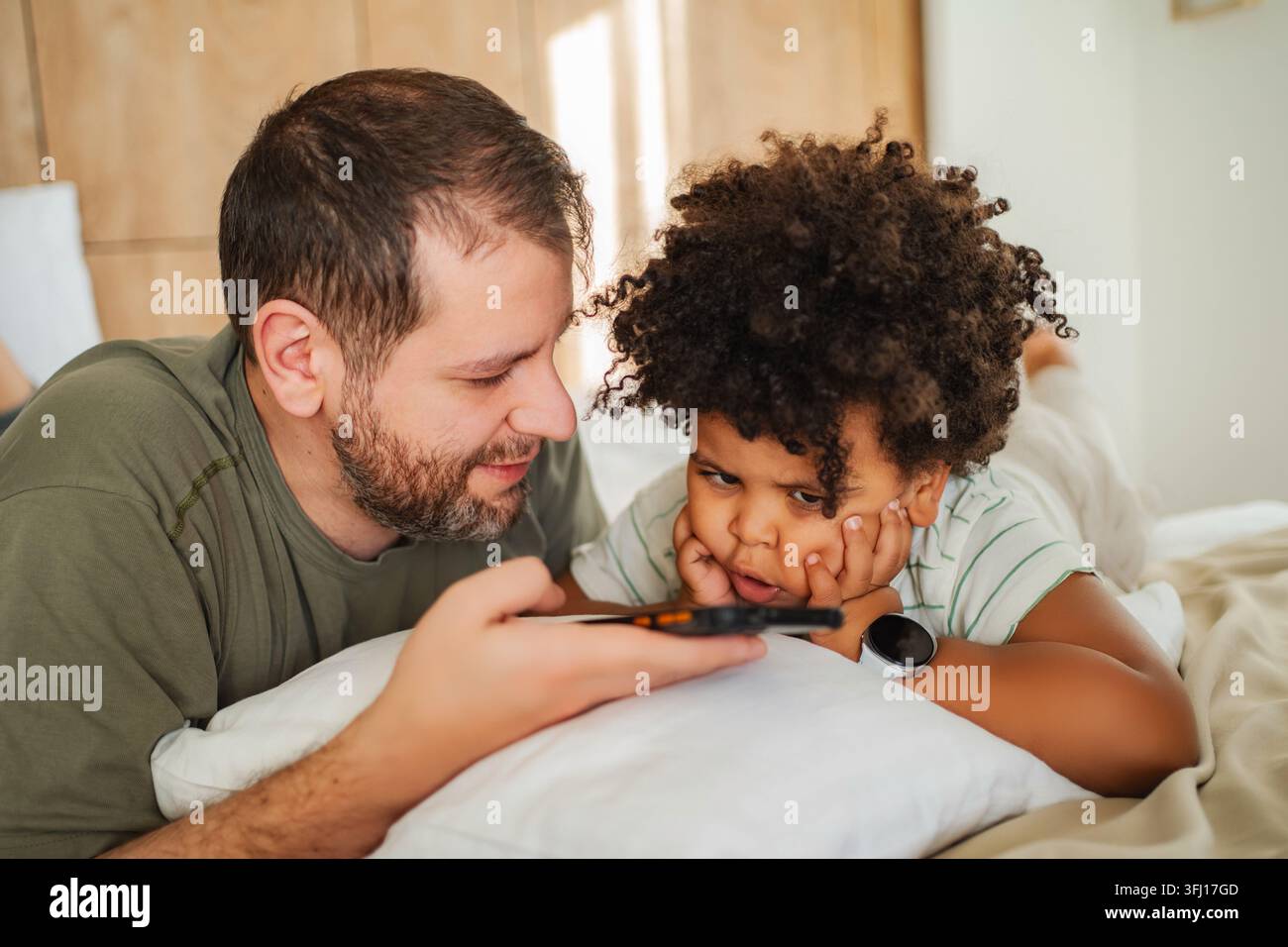 Padre e figlio legano con lo smartphone a casa Foto Stock