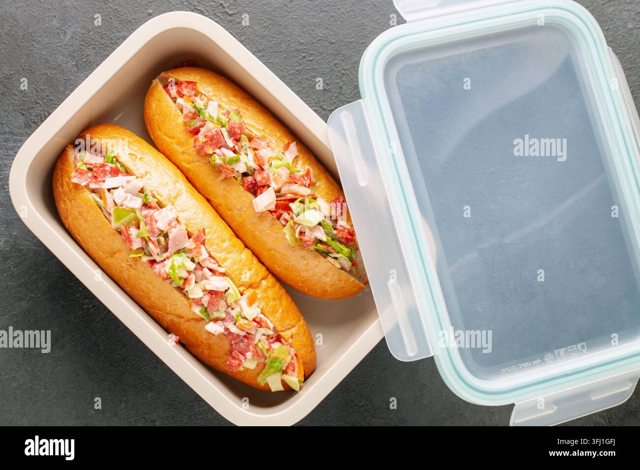 Panino all'italiana tritato. Panini hot dog con lattuga, salsicce e verdure in un contenitore. Cibo di tendenza. Vista dall'alto Foto Stock