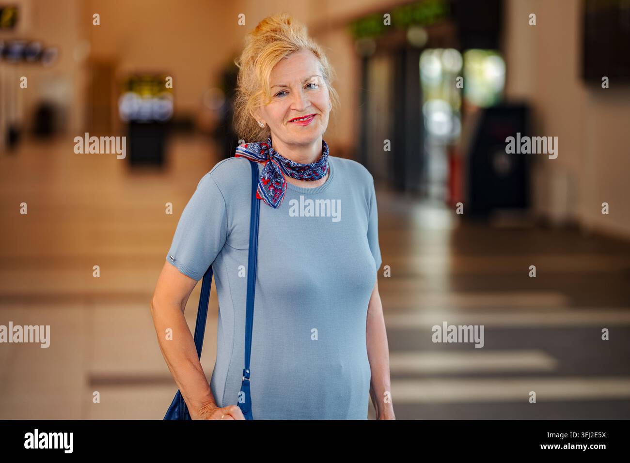 Donna adulta matura che sorride e viaggia in aeroporto Foto Stock