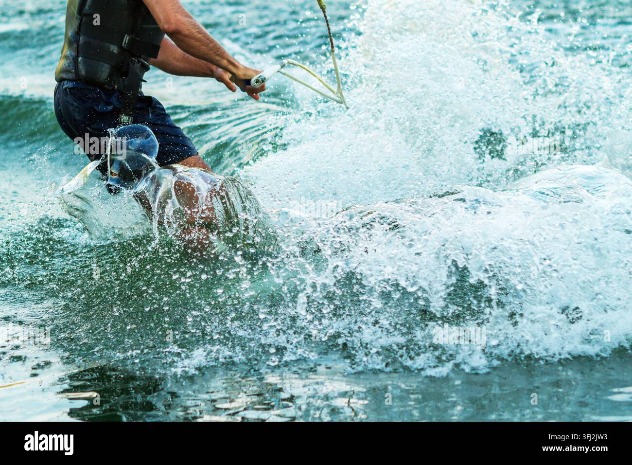 Gambe di un wakeboarder in un grande spruzzo d'acqua su un lago Foto Stock