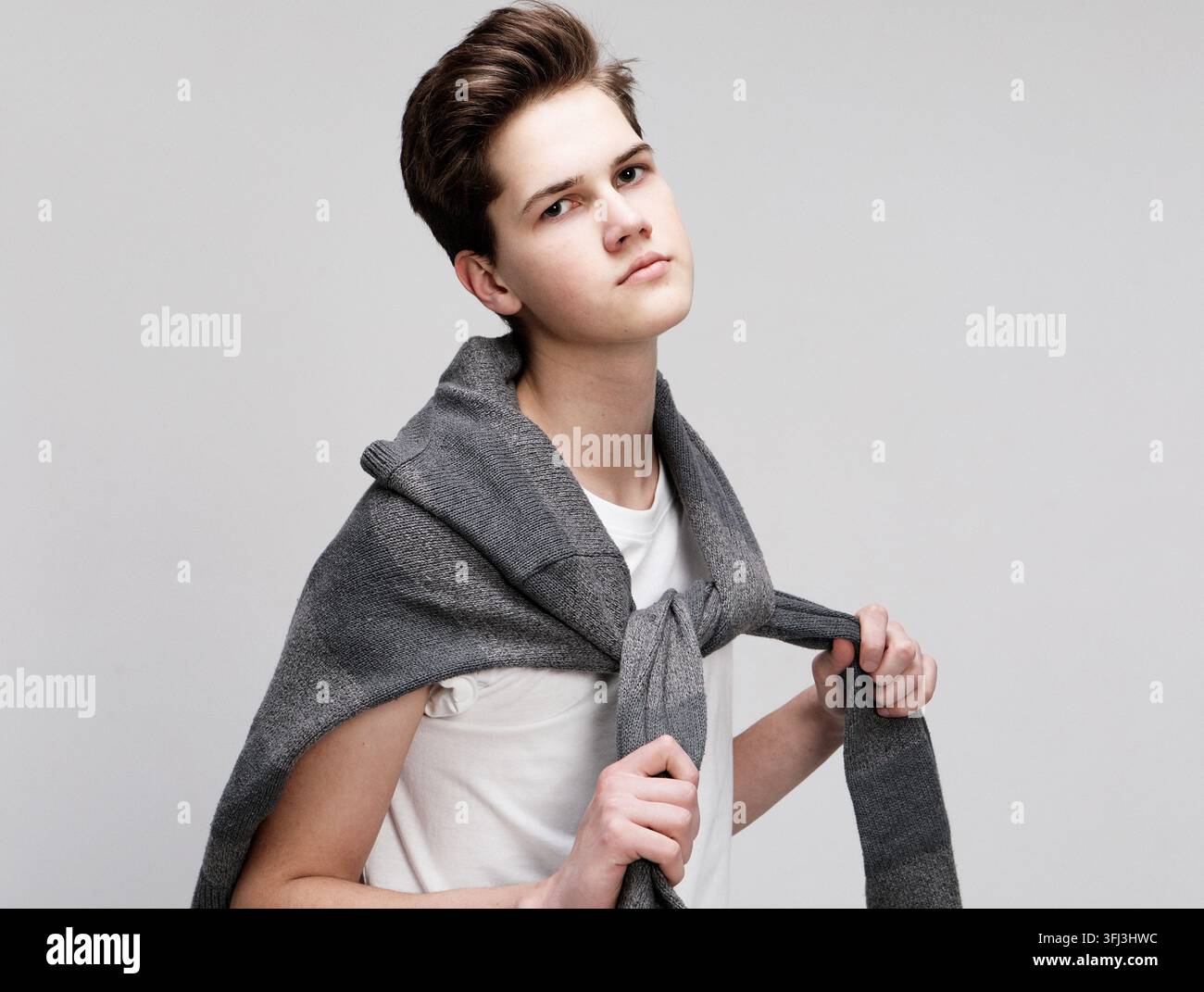 Giovane e affascinante ragazzo hipster adolescente che posa su uno sfondo bianco isolato Foto Stock