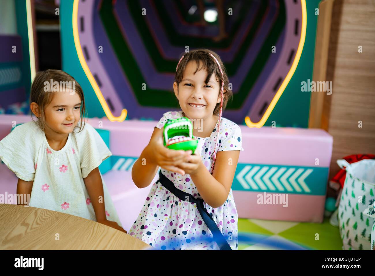 Due felici bambine in età scolare che giocano a un gioco di giocattoli Foto Stock