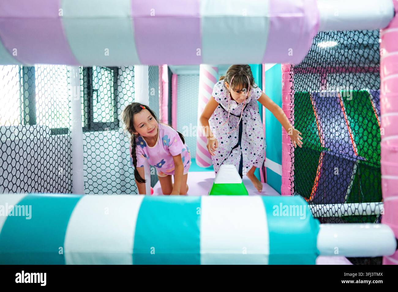 Ragazze felici che giocano in una struttura colorata da parco giochi al coperto Foto Stock