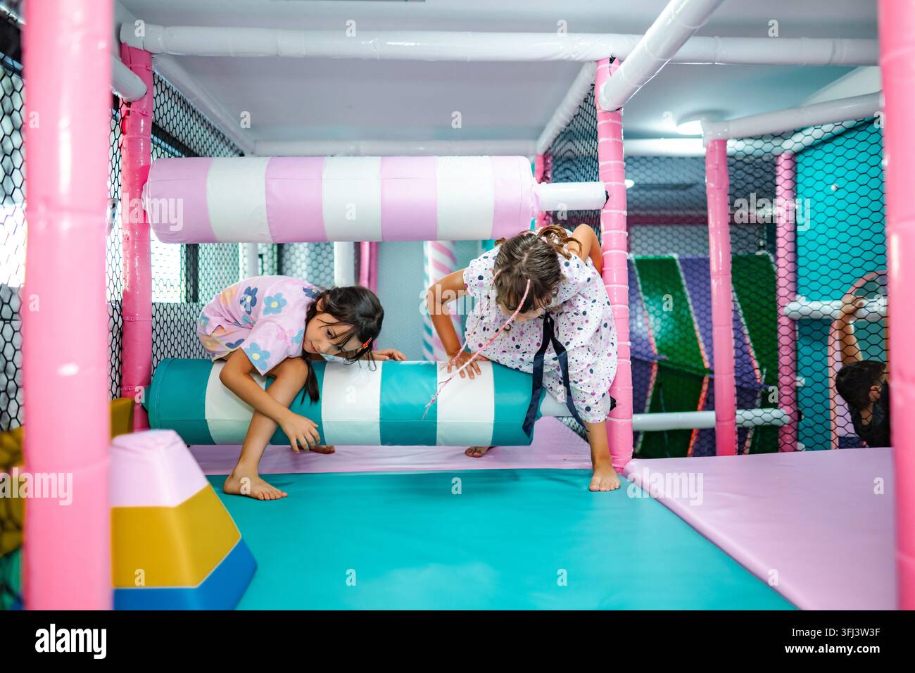 Ragazze che si divertono giocando in un parco giochi indoor colorato Foto Stock