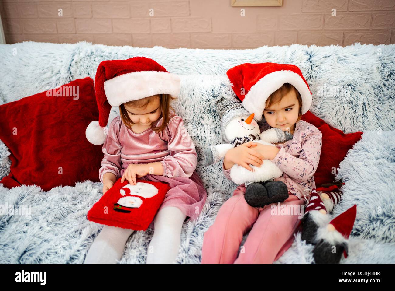 Ragazze con cappelli di Babbo Natale che celebrano il Natale insieme a casa Foto Stock