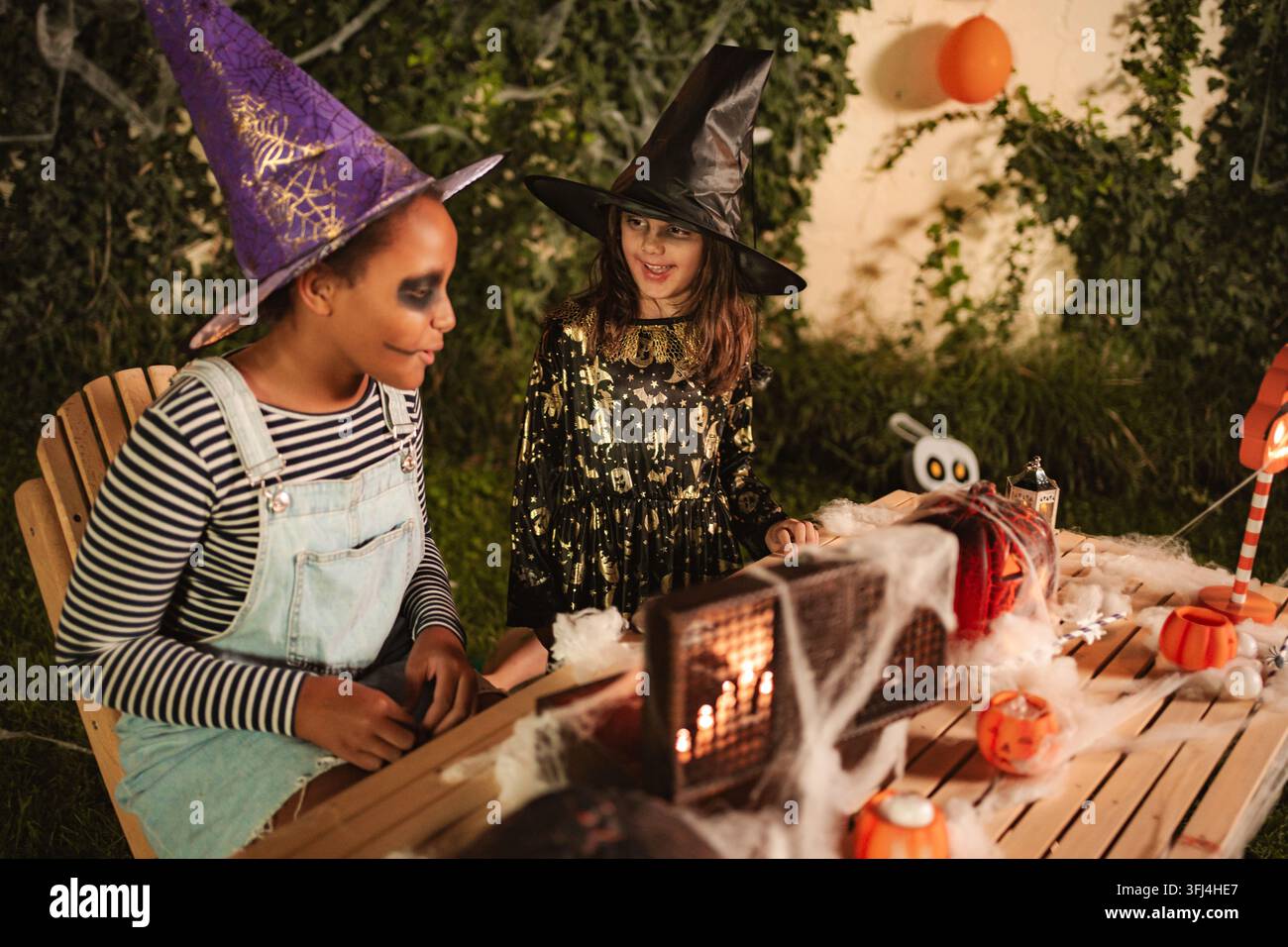 Due bambine in costumi da strega che celebrano una festa di Halloween Foto Stock