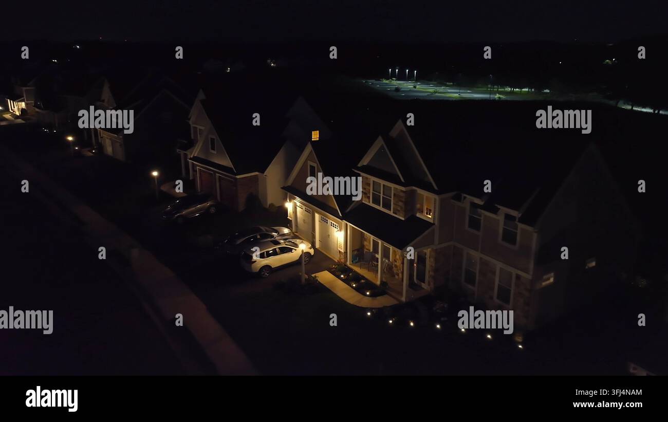 Quartiere americano esclusivo di notte. Avvicinamento aereo verso una casa buia con le luci accese sul portico, Eden, Pennsylvania. Foto Stock