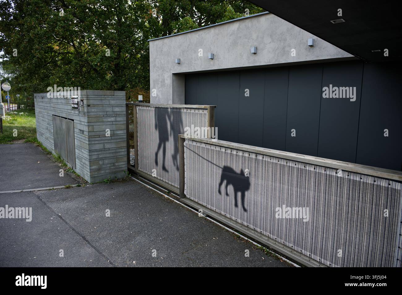Figure in stencil nero di una persona e di un cane dipinte su un cancello residenziale vicino a Strahov. Foto Stock