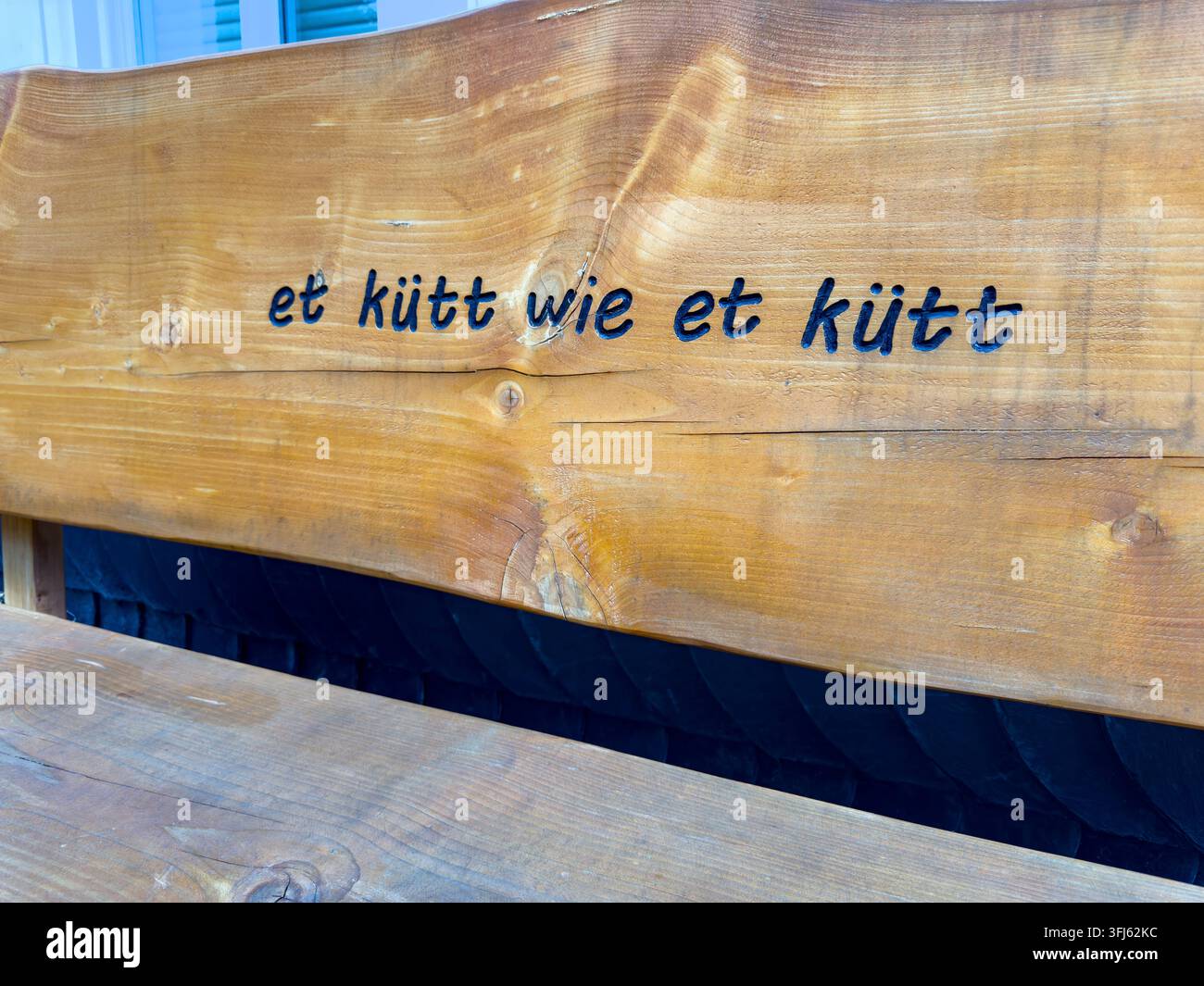 Scrittura in dialetto renano "et Kuett as et Kuett" – in tedesco standard significa "viene come viene" – incisa nello schienale di una panchina di legno, Germania Foto Stock