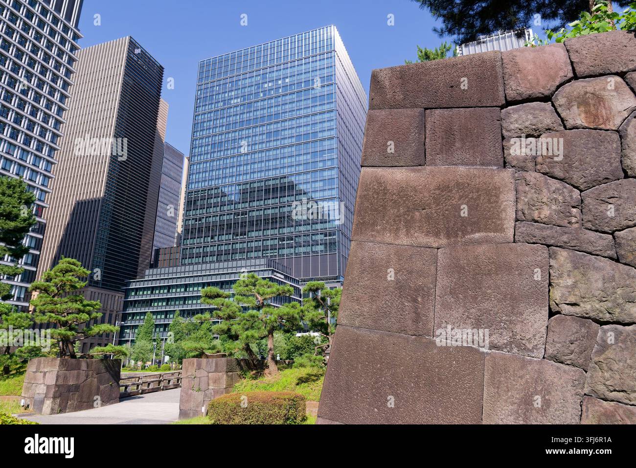 Un contrasto sorprendente tra i muri di pietra grezza secolari del periodo Edo e i grattacieli futuristici in vetro di Tokyo. Questo patrimonio culturale Foto Stock