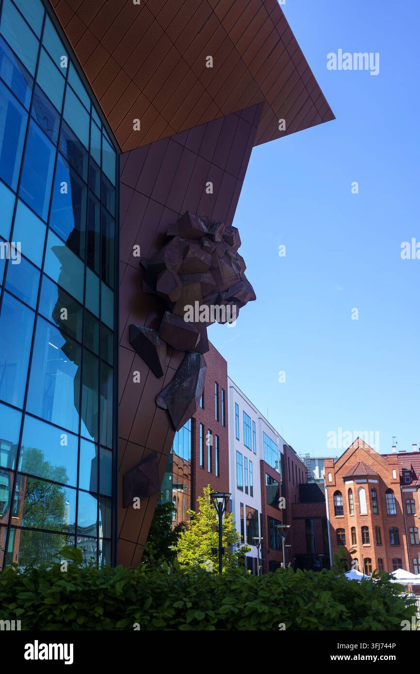 Danzica, Polonia – 26 maggio 2026 – Architettura moderna con una scultura di leone sulla facciata del centro commerciale Forum Danzica. Foto Stock