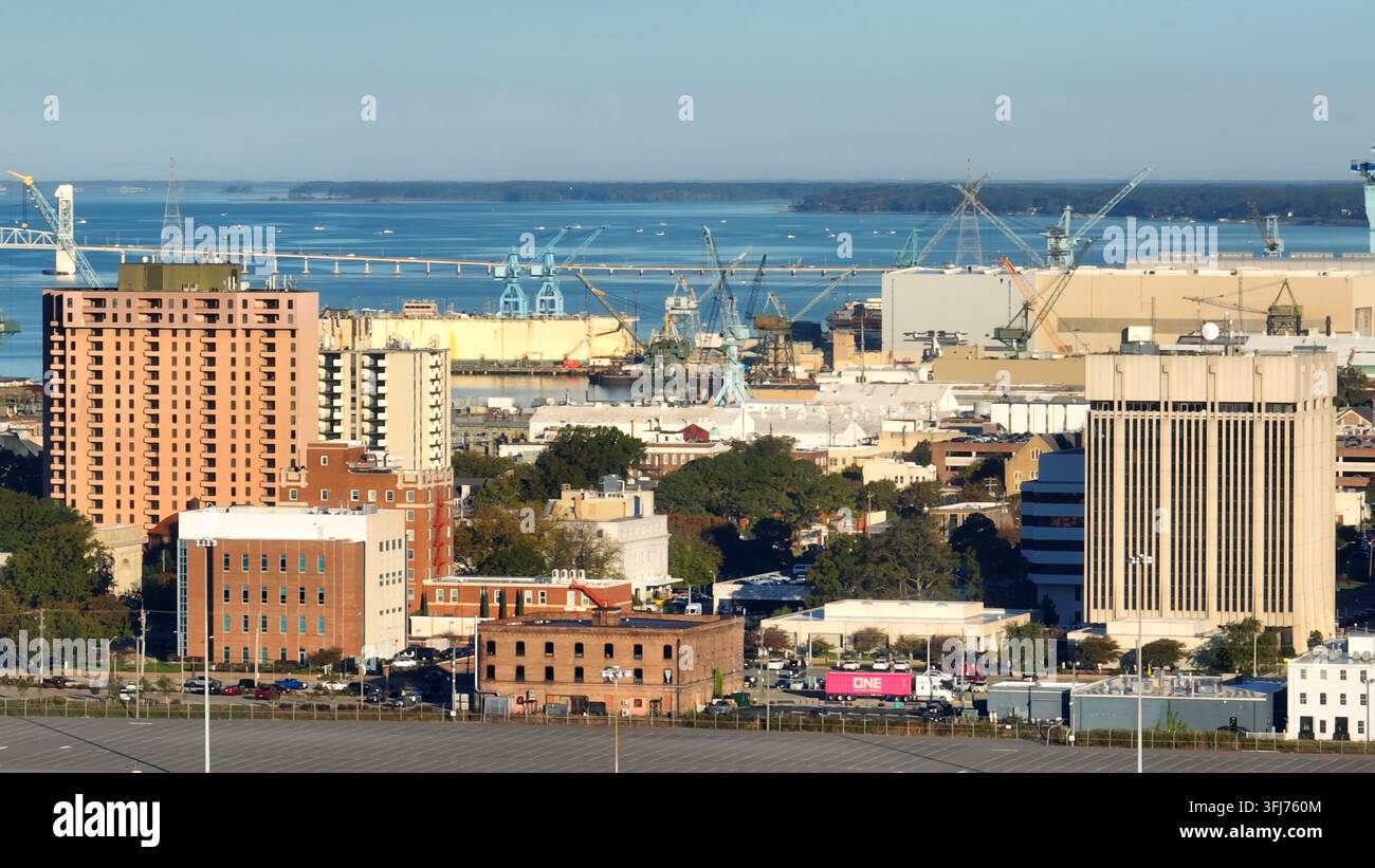 Newport News, skyline della Virginia. Ripresa aerea con movimento di panoramica di edifici, cantieri navali e del fiume James. Foto Stock