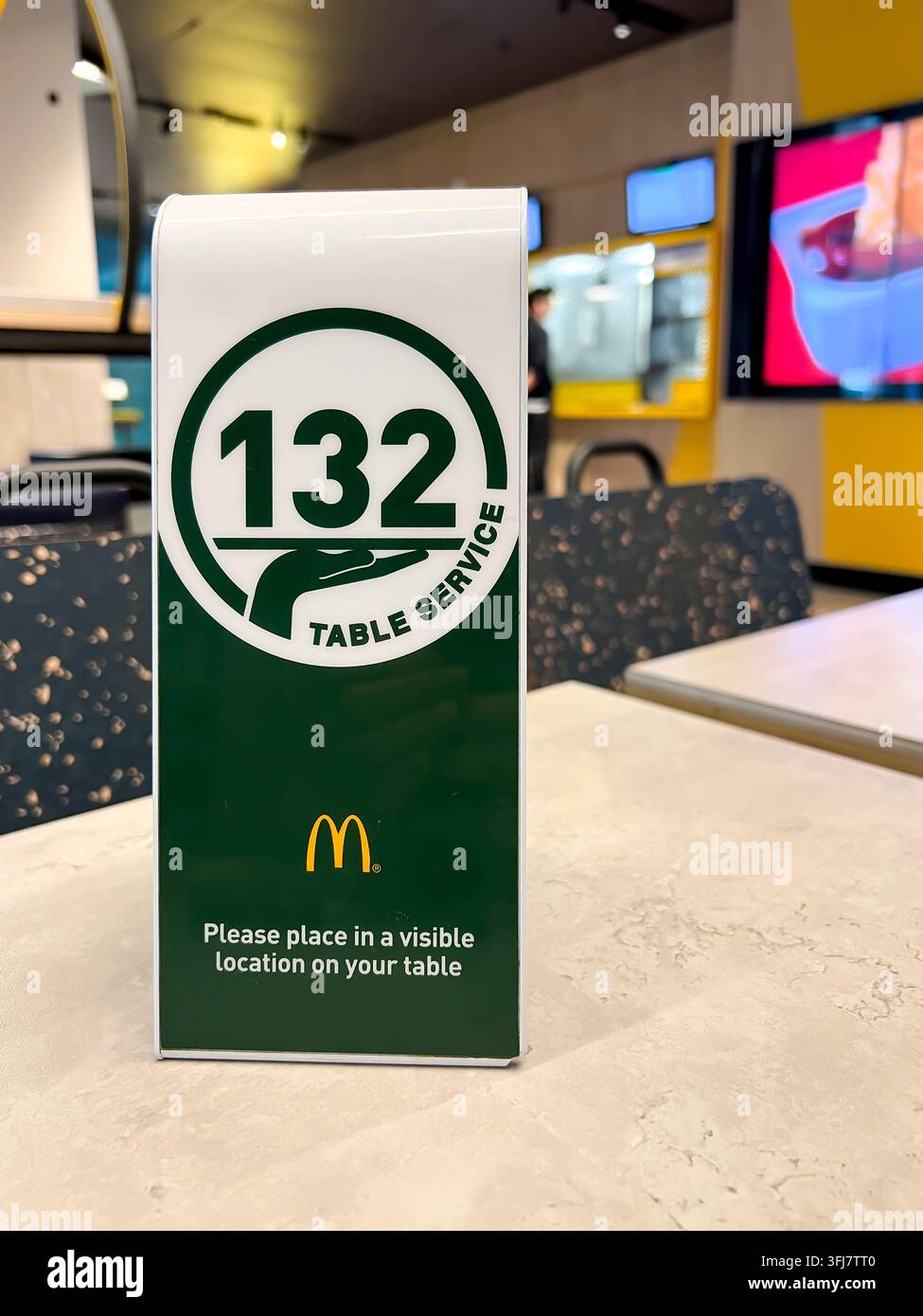 Un marcatore di servizio tavolo numerato per permettere a un membro del personale di un ristorante fast food McDonalds di sapere dove portare il vostro cibo. - Immagine stock catturata con smartphone