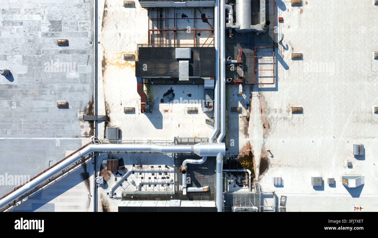 Tetto di un edificio industriale con unità di ventilazione e climatizzazione HLK insieme a tubi. Ripresa aerea con dolly inverso e vista dall'alto, Lancaster, Pen Foto Stock