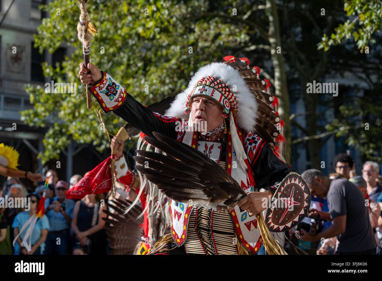 Gli anziani Lenape e i ballerini tradizionali accolgono il bufalo mentre pupazzi di bufalo a grandezza naturale sfrecciano per le strade di Lower Manhattan come parte del Foto Stock