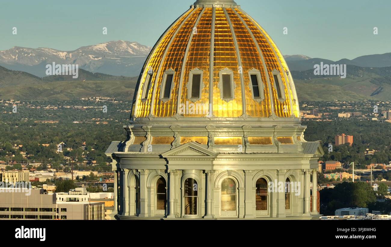 Cupola del Campidoglio del Colorado. Ripresa aerea ascendente dell'architettura artistica con le Montagne Rocciose sullo sfondo. Zoom lungo di Denver, capitale c Foto Stock