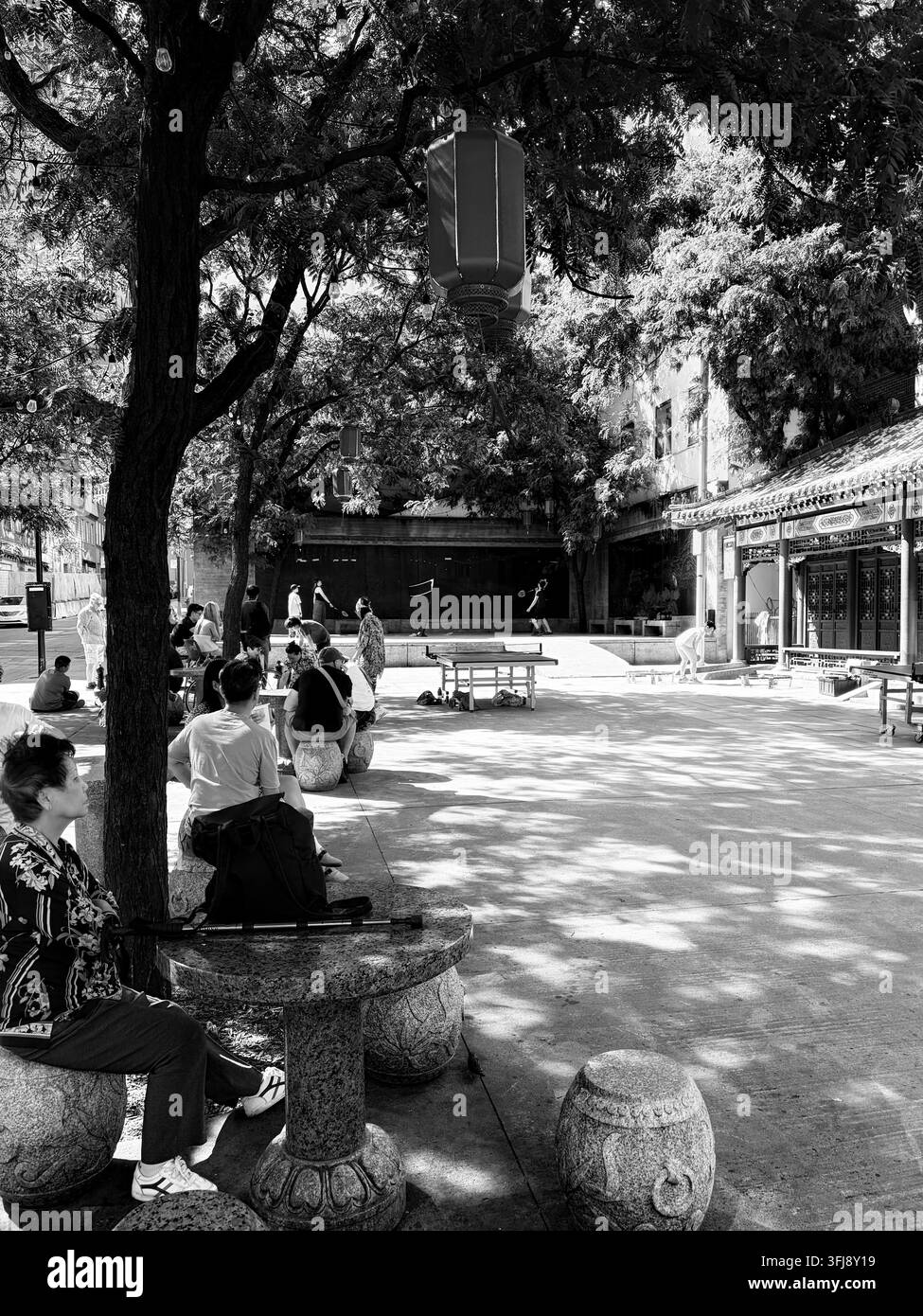 Persone che si rilassano in una piazza pubblica ombreggiata nel Chinatown di Montreal, Quebec, Canada Foto Stock