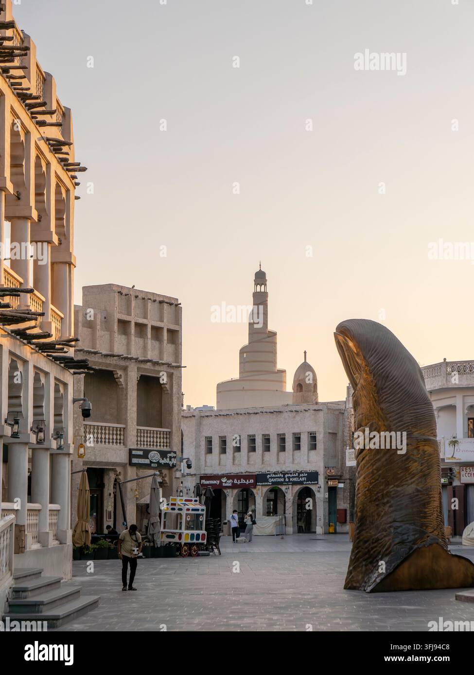 Scultura gigante in bronzo Le Pouce che raffigura un pollice, situata in una piazza lastricata a Souq Waqif Foto Stock