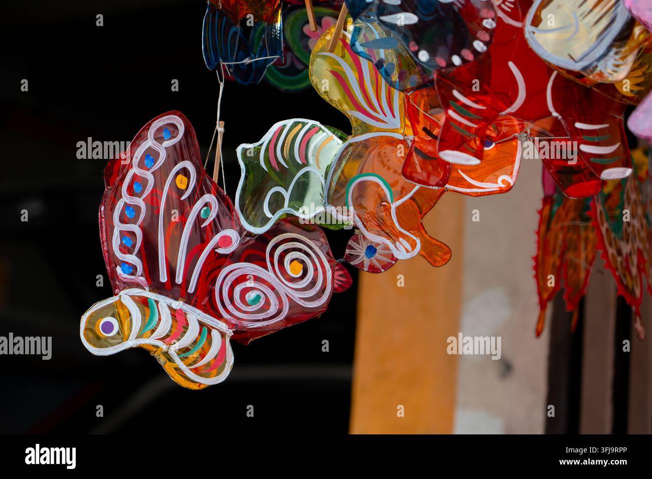Lanterne di cellophane a farfalla realizzate a mano appese a una vetrina di mercato tradizionale, che mostrano colori vivaci e il patrimonio culturale asiatico per la metà dell'autunno Foto Stock