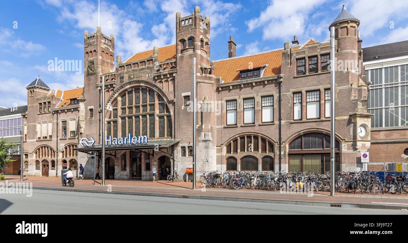 Haarlem, Paesi Bassi – 16 agosto 2026 – Vista esterna storica della stazione ferroviaria di Haarlem con iconica architettura in mattoni e parcheggio per biciclette. Foto Stock
