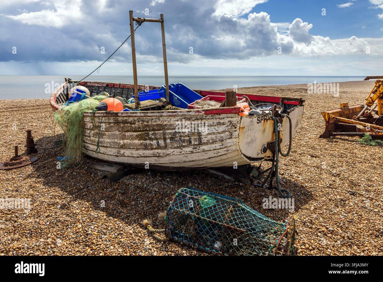 Vecchia barca da pesca di legno consumata su una spiaggia di ciottoli e ghiaia ad Aldeburgh nel Suffolk, Inghilterra. Foto Stock