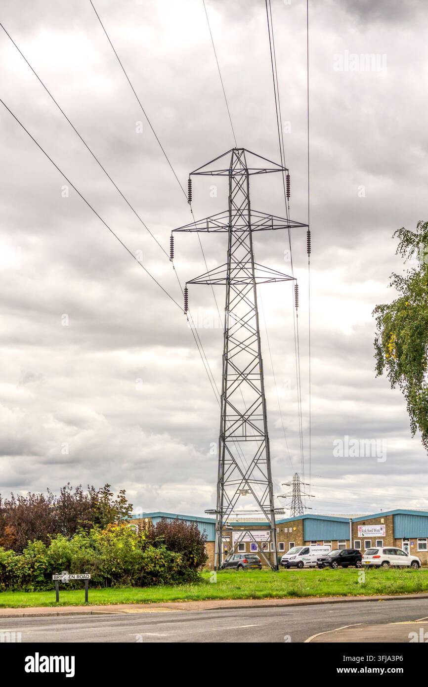 Una linea elettrica aerea che attraversa unità industriali nel King's Lynn Northern Industrial Estate nel Norfolk. Foto Stock