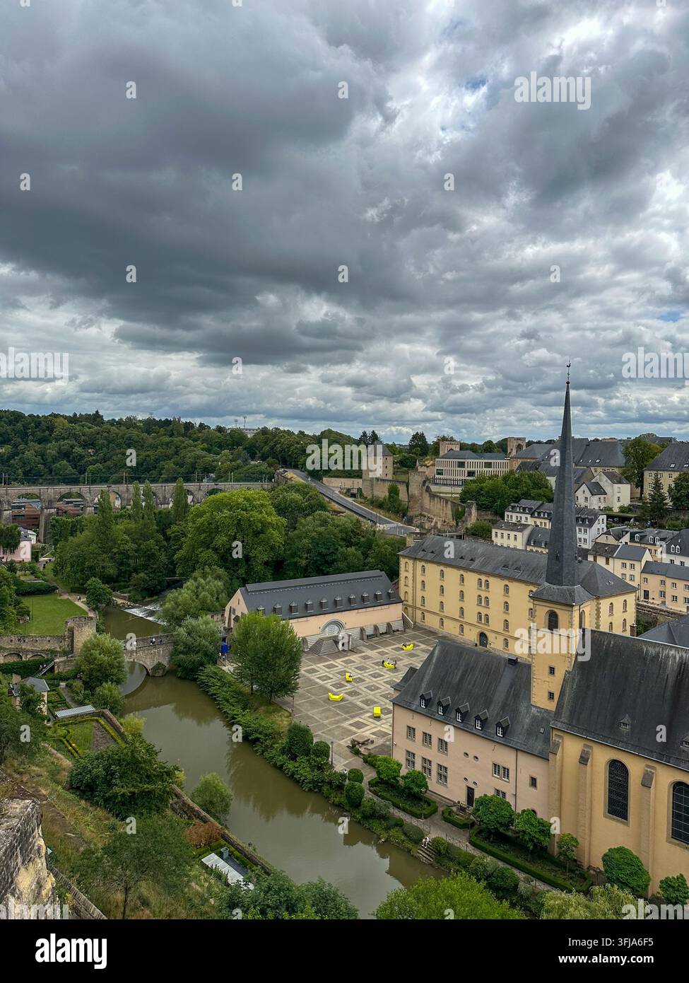 Panorama della città con chiesa storica e fiume sotto un cielo nuvoloso drammatico. Vista aerea panoramica di una vecchia città europea con una chiesa storica, torre Foto Stock