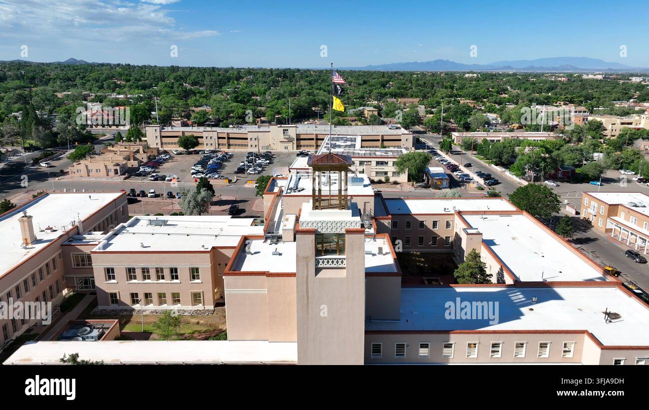 Edificio governativo dello Stato del New Mexico a Santa Fe, NM. Ripresa aerea in una bella giornata estiva. Zoom sulle bandiere americane, del New Mexico e delle POW-MIA. Foto Stock