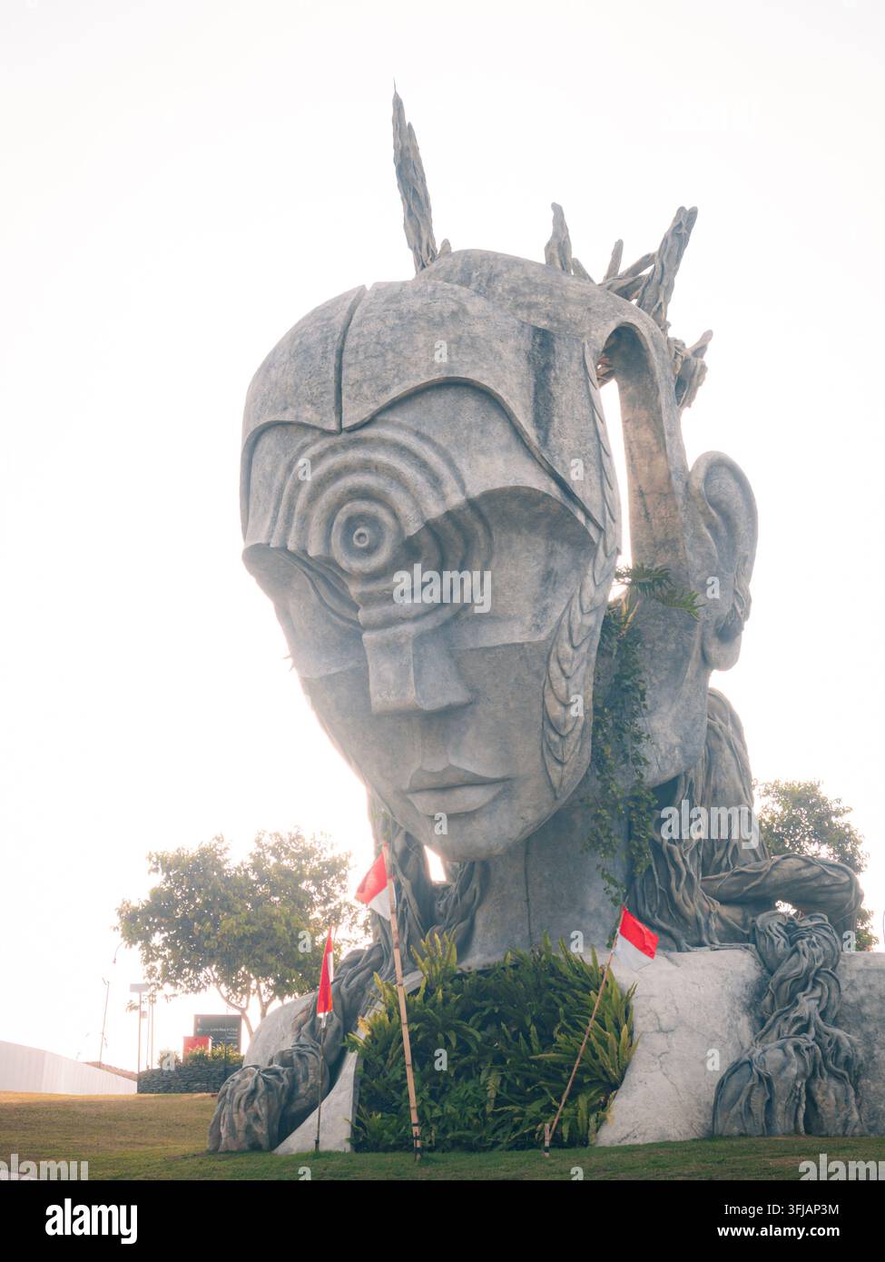 Prima di profilo di una scultura di volto massiccia a Nuanu Creative City illuminata dalla luce del tramonto. Foto Stock