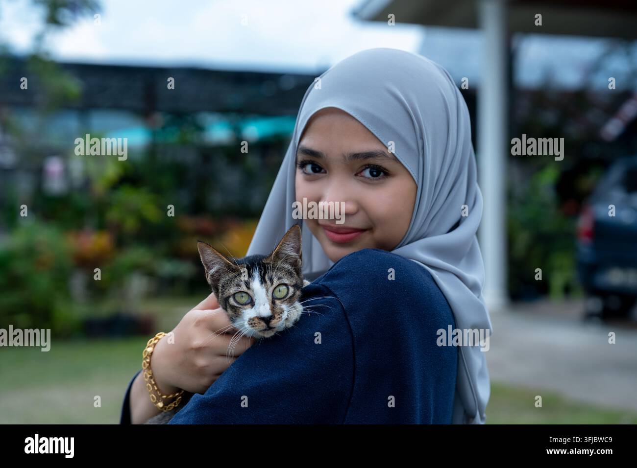 Giovane donna felice con gatto tabby Foto Stock